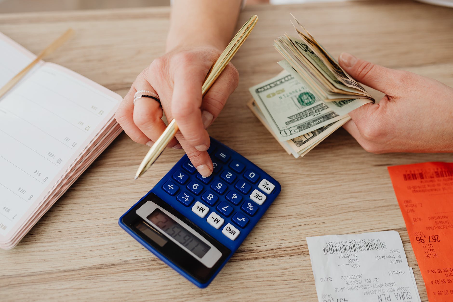 woman calculating money and receipts using a calculator